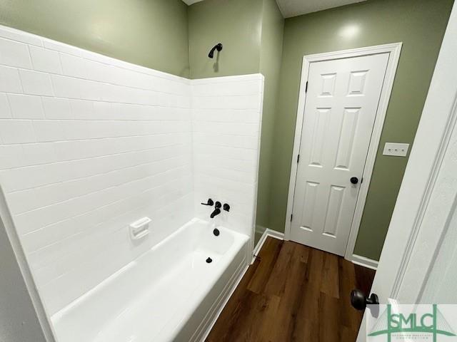 bathroom featuring wood-type flooring and bathtub / shower combination