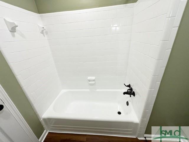 bathroom featuring wood-type flooring and tub / shower combination