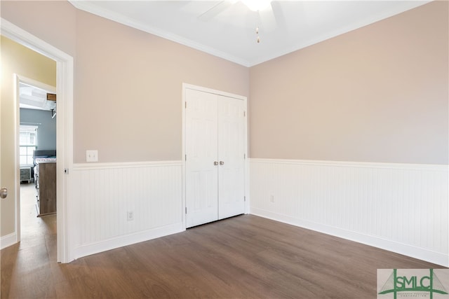 unfurnished bedroom with a closet, dark hardwood / wood-style floors, ceiling fan, and ornamental molding