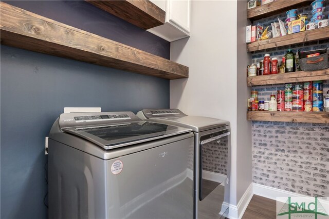 washroom with cabinets, independent washer and dryer, and hardwood / wood-style floors