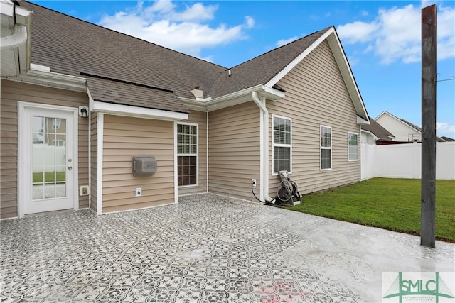 rear view of property featuring a lawn and a patio area