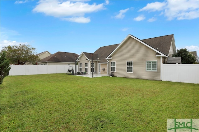 rear view of house featuring a lawn and a patio area