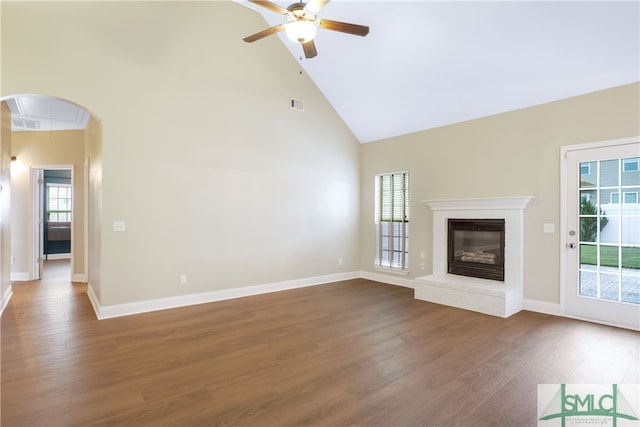 unfurnished living room with a brick fireplace, ceiling fan, high vaulted ceiling, and hardwood / wood-style flooring