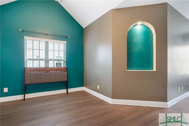 spare room with wood-type flooring and vaulted ceiling