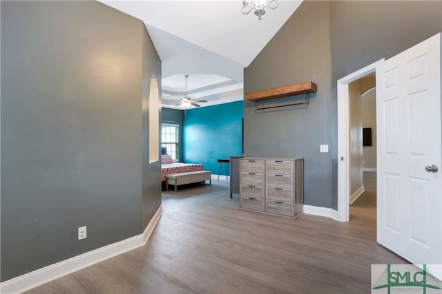 bedroom featuring hardwood / wood-style flooring, a raised ceiling, and lofted ceiling