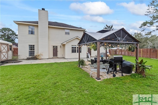 rear view of house featuring a storage shed, a patio area, and a lawn