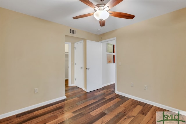 empty room with ceiling fan and dark wood-type flooring