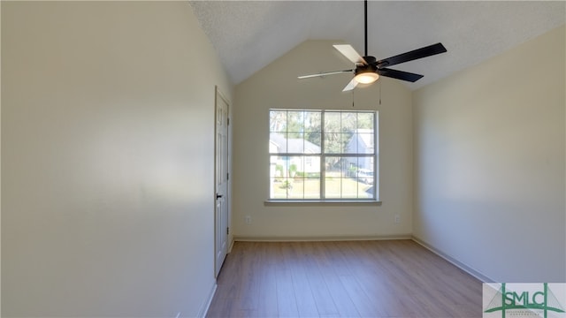 empty room featuring a textured ceiling, light wood-type flooring, ceiling fan, and lofted ceiling