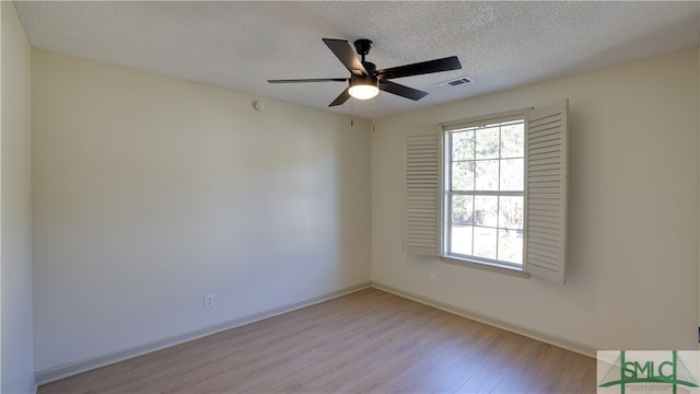 empty room with ceiling fan, a textured ceiling, and light wood-type flooring