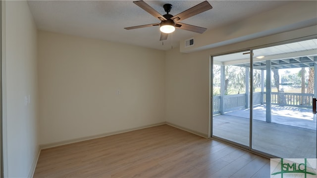 spare room featuring a textured ceiling, light hardwood / wood-style flooring, and ceiling fan