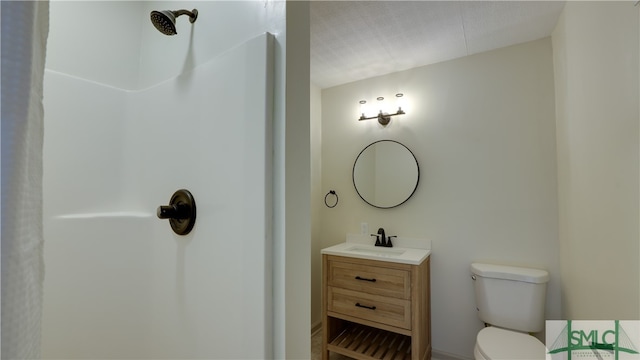 bathroom with a shower, vanity, and toilet