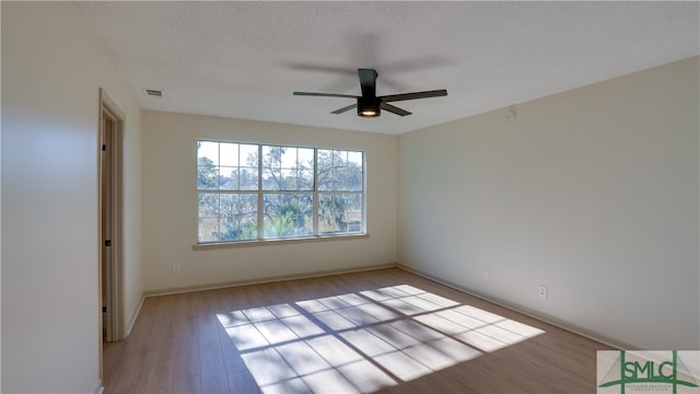 unfurnished room featuring ceiling fan, a textured ceiling, and light wood-type flooring