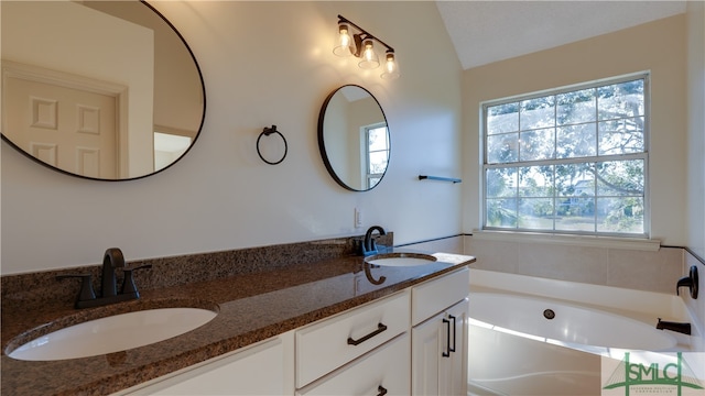 bathroom with vanity, vaulted ceiling, and a bathing tub