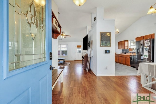 foyer entrance with ceiling fan, lofted ceiling, and light hardwood / wood-style floors