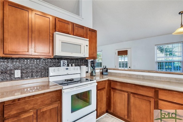 kitchen featuring pendant lighting, light tile patterned floors, white appliances, and decorative backsplash