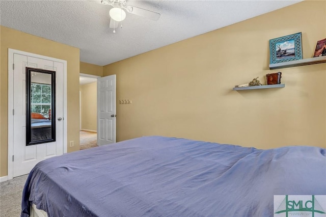 carpeted bedroom with a textured ceiling and ceiling fan