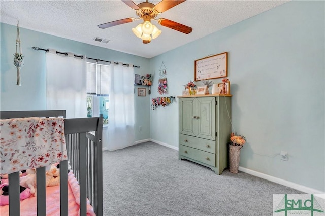 carpeted bedroom featuring ceiling fan and a textured ceiling