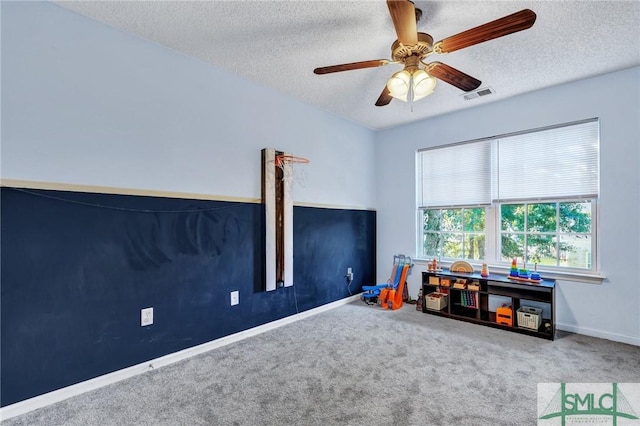 game room with carpet, ceiling fan, and a textured ceiling