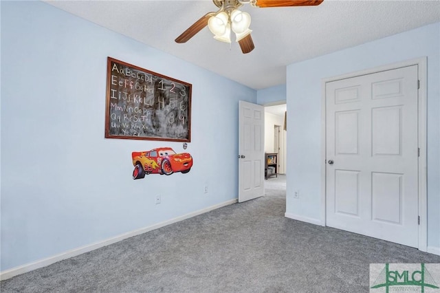 unfurnished bedroom featuring ceiling fan, carpet, and a textured ceiling