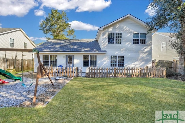 back of house featuring a playground and a yard