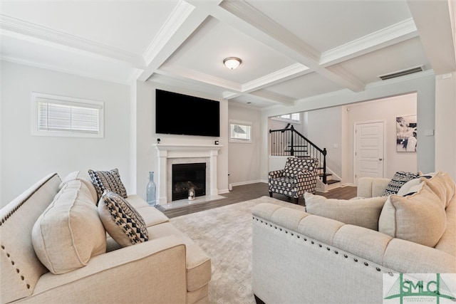 living room featuring beam ceiling, coffered ceiling, crown molding, a fireplace, and hardwood / wood-style flooring