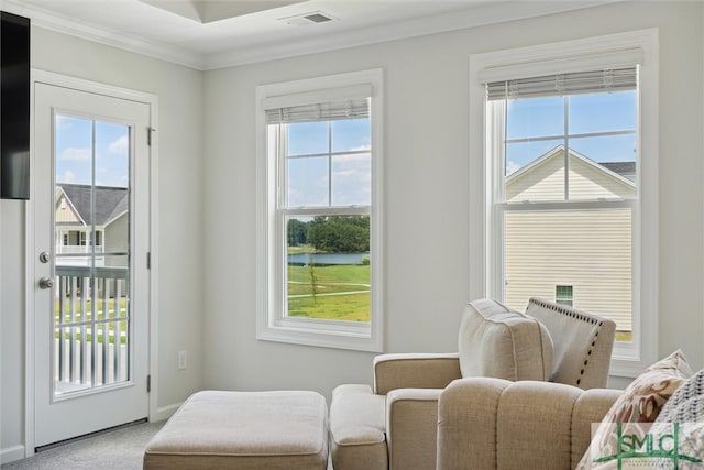 living area with light carpet, a wealth of natural light, and ornamental molding