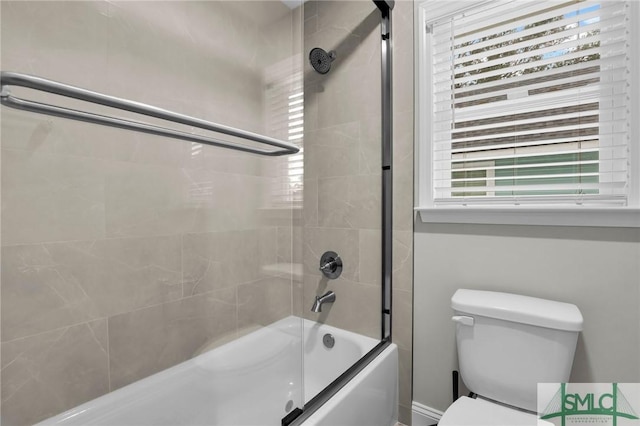 bathroom with a wealth of natural light, bath / shower combo with glass door, and toilet