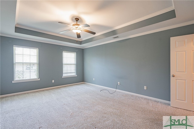 unfurnished room featuring carpet flooring, a raised ceiling, ceiling fan, and crown molding