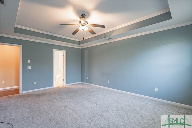 carpeted spare room with a tray ceiling, ceiling fan, and ornamental molding