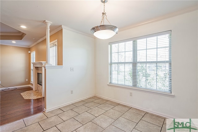 unfurnished dining area with decorative columns, crown molding, and light hardwood / wood-style flooring