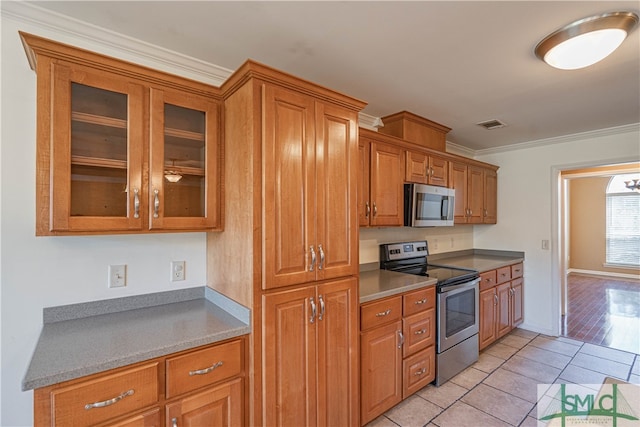 kitchen featuring crown molding, light hardwood / wood-style flooring, and stainless steel appliances