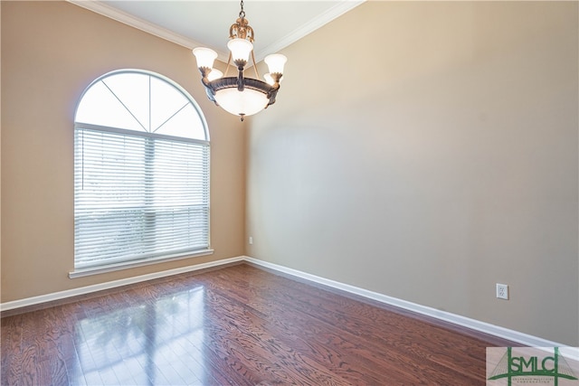 spare room featuring dark hardwood / wood-style floors, crown molding, and an inviting chandelier