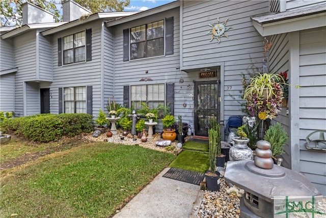 property entrance with a lawn