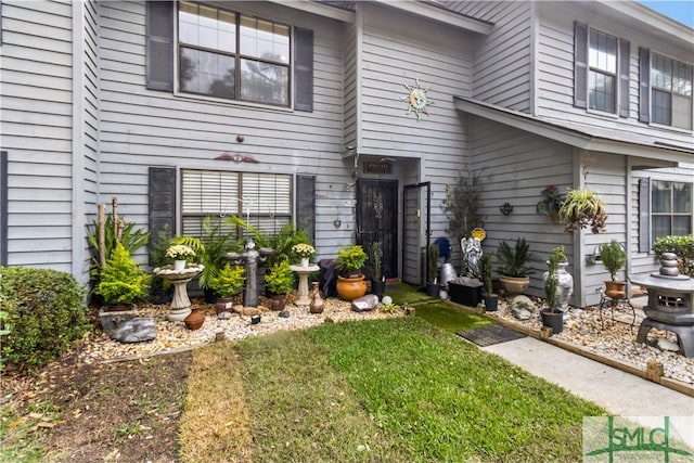 view of exterior entry with a yard