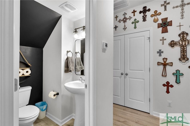 bathroom with hardwood / wood-style floors and toilet