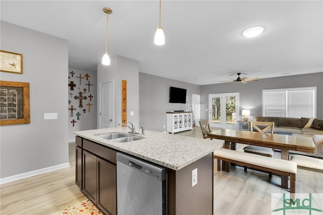 kitchen featuring pendant lighting, dishwasher, a kitchen island with sink, sink, and ceiling fan