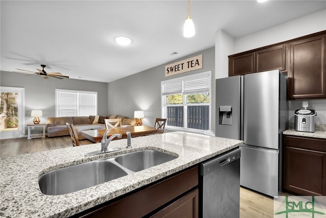 kitchen featuring sink, light hardwood / wood-style flooring, light stone countertops, and appliances with stainless steel finishes