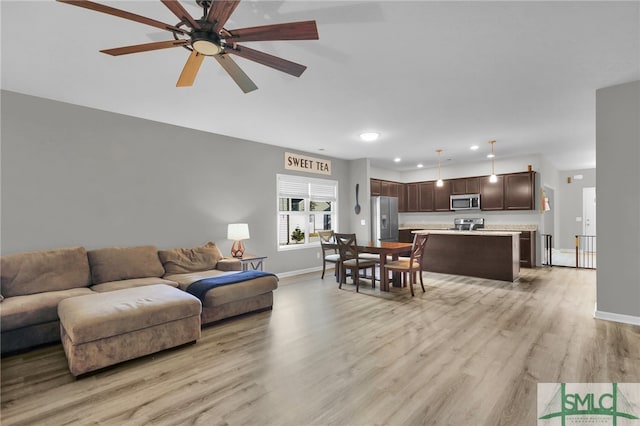 living room with ceiling fan and light wood-type flooring