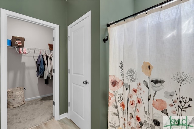 bathroom with curtained shower and wood-type flooring