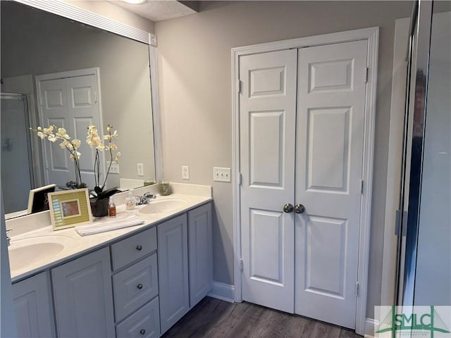 bathroom with hardwood / wood-style flooring, vanity, and walk in shower