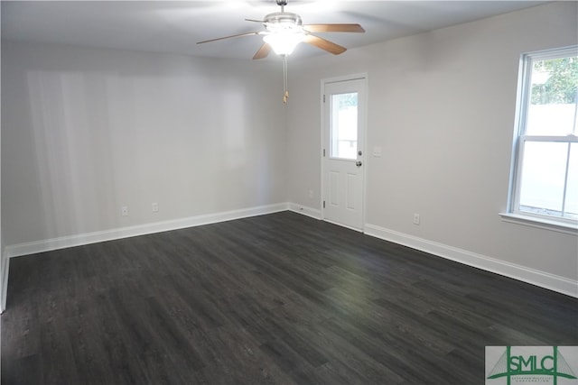 empty room with ceiling fan, a healthy amount of sunlight, and dark hardwood / wood-style floors