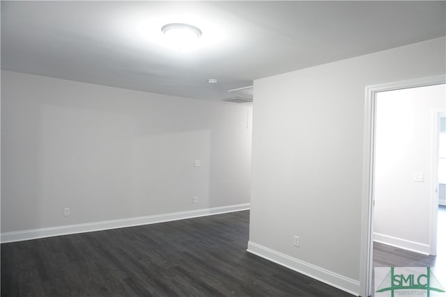 unfurnished room with dark wood-type flooring