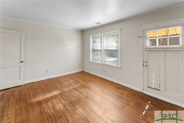 interior space featuring a wealth of natural light, hardwood / wood-style floors, and crown molding