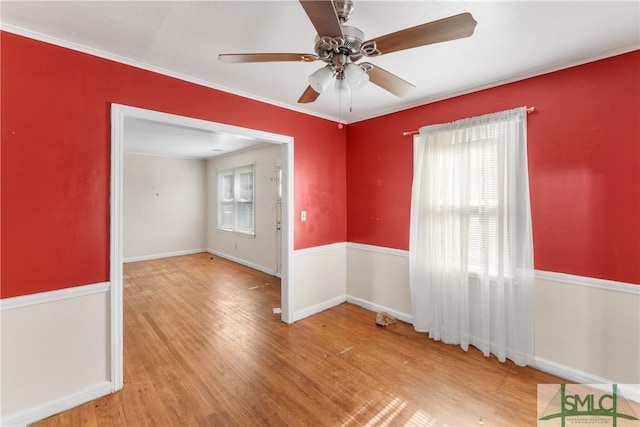 empty room with ceiling fan, a healthy amount of sunlight, light wood-type flooring, and ornamental molding