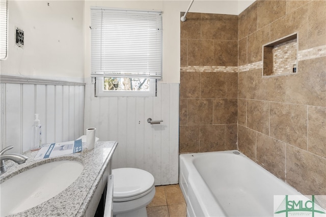 full bathroom featuring tile patterned flooring, vanity, toilet, and tiled shower / bath combo