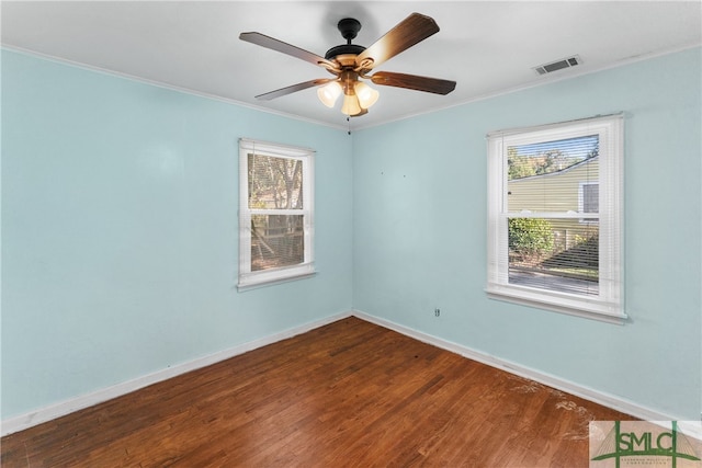 unfurnished room with ornamental molding, a healthy amount of sunlight, and hardwood / wood-style flooring