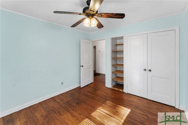 unfurnished bedroom with a closet, ceiling fan, crown molding, and dark hardwood / wood-style floors