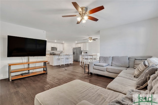 living room featuring ceiling fan and dark hardwood / wood-style flooring