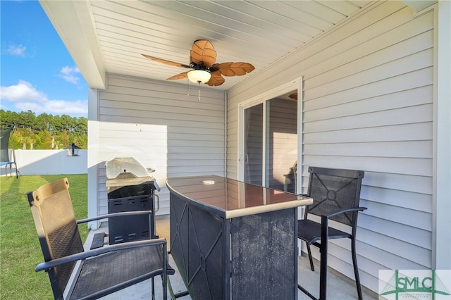 view of patio featuring a grill, ceiling fan, and exterior bar