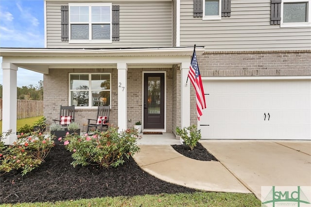 doorway to property featuring covered porch and a garage